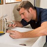 Plumber working on faucet