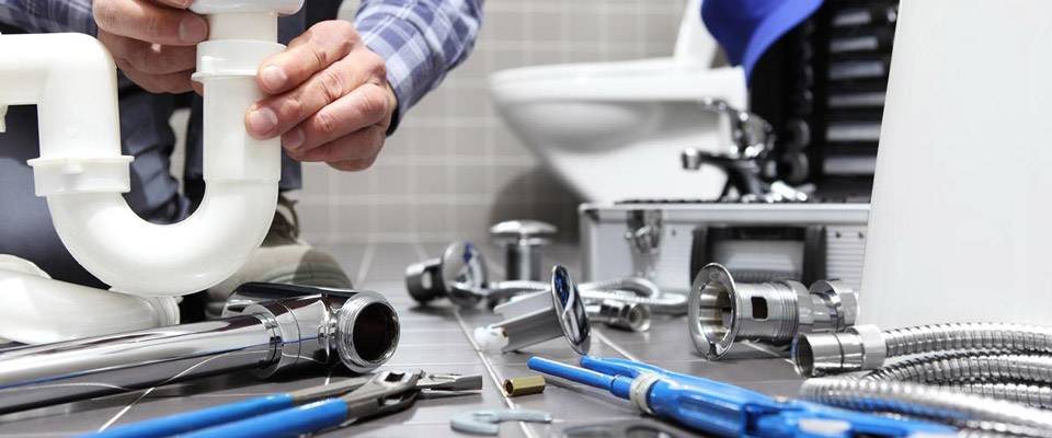 plumber with pipes and toilet in background